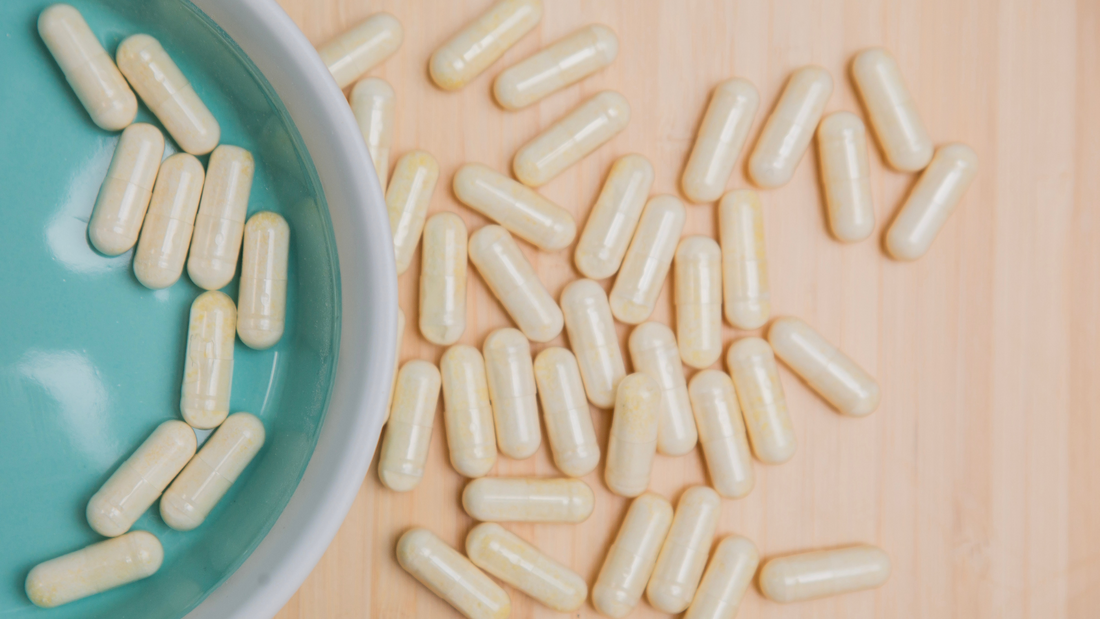 Capsules of L. plantarum PS128 in a ceramic dish and on a wooden table