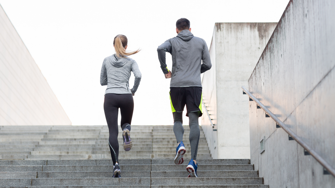 Man and woman running up a flight of stairs