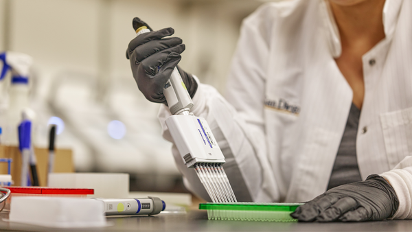 Scientist pipetting media, perhaps for PS128 which affects brain serotonin and dopamine and provides dietary support for autism