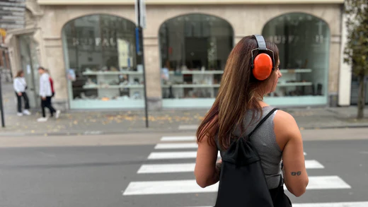 หญิงออทิสติกสวมหูฟังตัดเสียงรบกวนขณะรอข้ามถนน